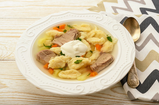 Meat soup with dumplings on white background.