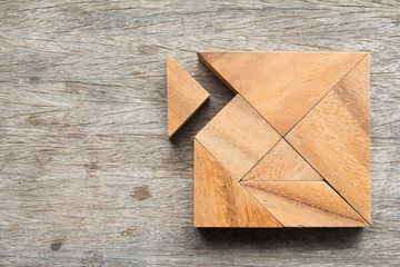 Tangram puzzle wait for fulfill to square shape on wooden table