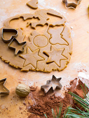 Cookies forms and gingerbread dough on wooden pastry board