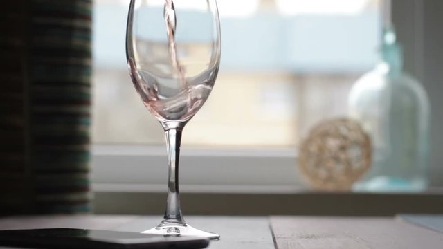 pouring red wine in goblet on table in cafe