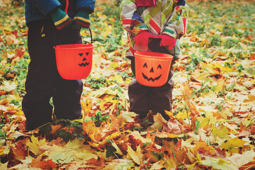 little boy and girl trick or treating in fall nature