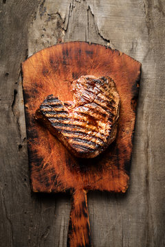 grilled juicy steak on a cutting board on a wooden background. top view