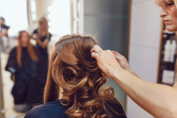 Hair stylist makes the bride before wedding