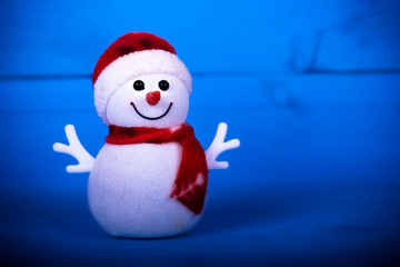 Fun Christmas snowman on a blue wooden background.