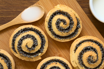 Hausgemachte Mohnschnecken mit Zuckerguss an der Seite, fotografiert mit natürlichem Licht