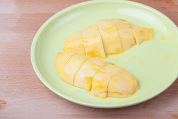 Cut  ripe yellow mango in green dish