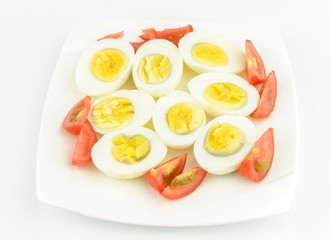 tomatoes and boiled eggs on a white plate
