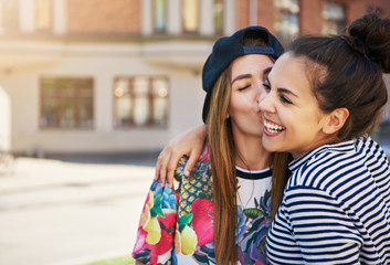 Fototapeta premium Affectionate young woman kissing her friend