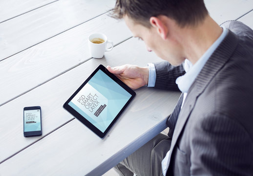 User with Tablet and Smartphone at Blue Wooden Table Mockup