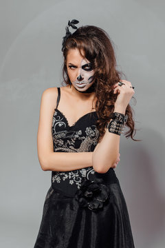 Portrait of young woman with skull make-up.