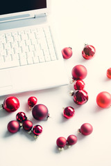 Red christmas baubles and laptop computer