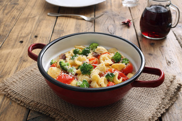 pasta italiana orecchiette con verdure in tegame di metallo sfondo legno rustico