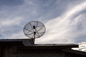 Satellite dish on zinc roof in the sunset