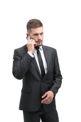 Fototapeta premium Handsome businessman in suit using the phone in office