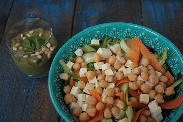 vegan salad with chickpeas, carrot, cucumber, tofu and pesto in a glass