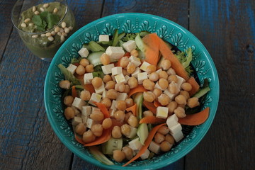 vegan salad with chickpeas, carrot, cucumber, tofu and pesto in a glass