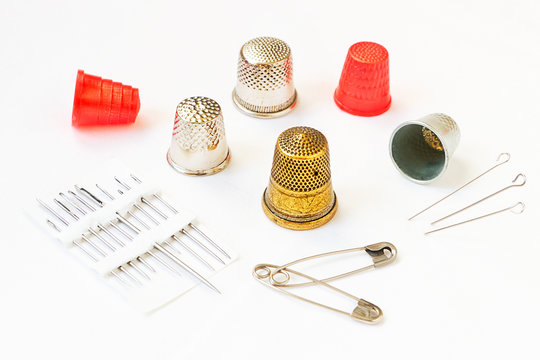 Various thimbles and sewing needles