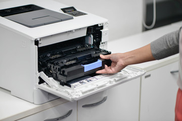 Business woman is reloading the printer cartridges of laserjet printer