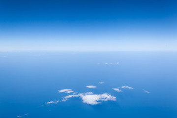 Fototapeta na wymiar Piękny widok z samolotu na horyzont - błękitne niebo nad chmurami i ocean