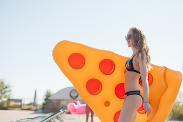 Girl running keep in hands the pizza mattress