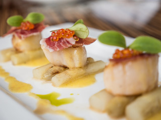 Seared scallops with salmon roe, ham and asparagus