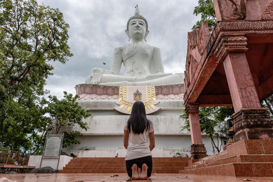 The girl was praying for blessings on a huge white Buddha.