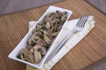 funghi champignon trifolati su piatto rettangolare