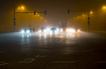Berufsverkehr in einer Stadt bei Dunkelheit und Nebel