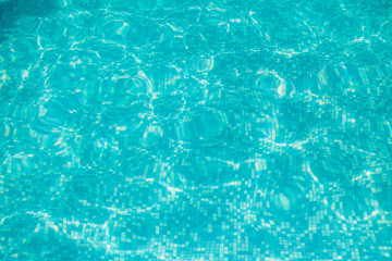 Blue pool water with sun reflections