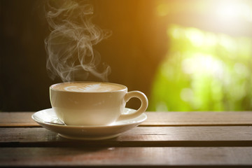 Hot coffee on a wooden table on the terrace.