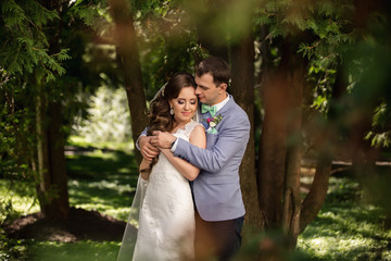 Wedding couple. Elegant bride and groom hugging in the fairy forest after wedding ceremony