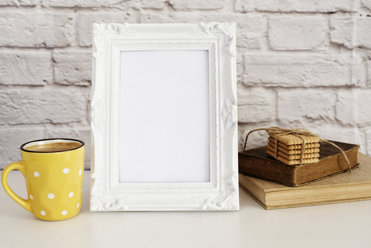 Frame Mockup. White Frame Mock Up. Yellow Cup Of Coffee With White Dots, Cappuccino, Latte, Old Books, Cookies. Display Mock-Up, Styled Stock Photography . Empty Rustic Frame. Gray Brick Wall. 