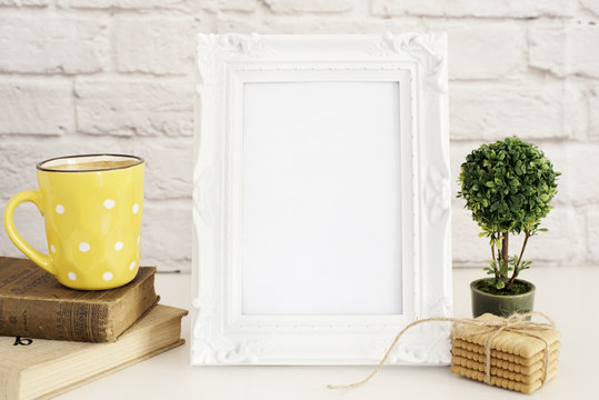 Frame Mockup. White Frame Mock Up. Yellow Cup Of Coffee With White Dots, Cappuccino, Latte, Old Books, Cookies. Display Mock-Up, Styled Stock Photography. Empty Rustic Frame. Gray Brick Wall