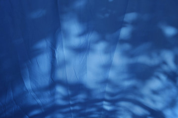 Crumpled blue fabric with shadows