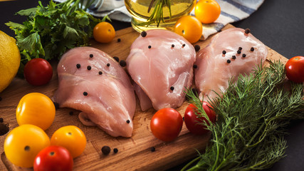 Raw chicken breast fillets and vegetable on wooden background © radiomarlena
