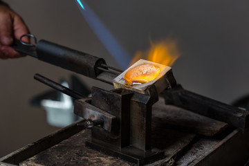 Close-up of Silver Casting from Crucible to Metal Mold with blowtorch; Goldsmith Workshop; - 124891152
