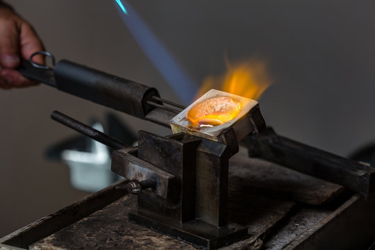 Close-up of Silver Casting from Crucible to Metal Mold with blowtorch; Goldsmith Workshop;