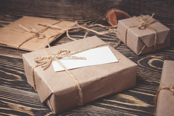 Vintage gift box with blank tag on old wooden background.