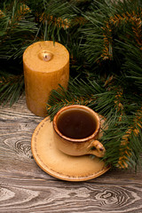 Obraz na płótnie Canvas Small cup of coffee, candle and fir branch on wooden background