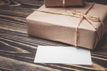 Vintage gift box with blank tag on old wooden background.