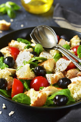 Italian salad panzanella with chicken and lamb`s lettuce.