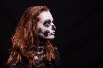 profil d'une femme à la chevelure rousse maquillée en squelette sur fond noir © Olivier Tabary