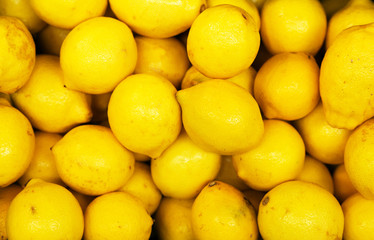 Lot of bright yellow lemons in supermarket.
