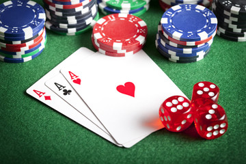 Playing cards, poker chips, and dices on green table
