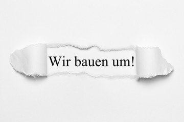 Wir bauen um! auf weißen gerissenen Papier