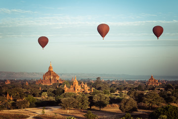 Hot air balloons flying at sunrise over ancient Buddhist Temples at Bagan. Myanmar (Burma) travel landscape and destinations