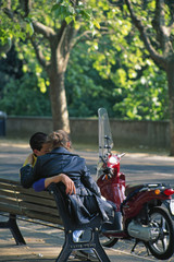 Fototapeta na wymiar couple on bench w red motorcycle