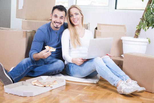 Couple moving Into new home and eating pizza