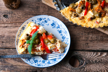 Greek tart with feta cheese and olives. Wooden rustic table
