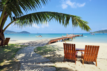Obraz na płótnie Canvas Two beach chairs on idyllic tropical beach.